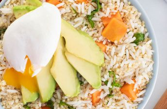 Grains breakfast bowl with jasmine rice, quinoa, poached eggs, avocado and sweet potato