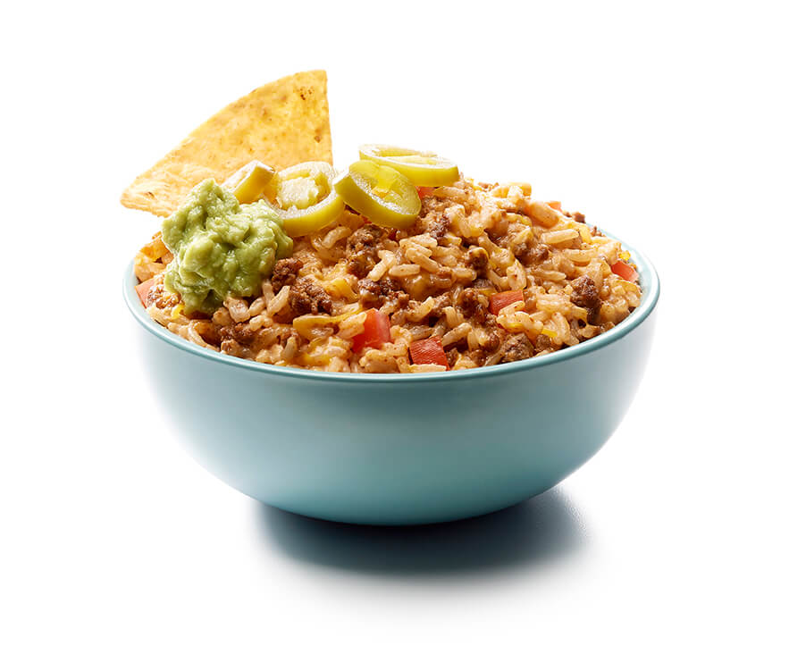 Bowl with loaded nacho jasmine rice dip with jalapeños, guacamole and tortilla chips