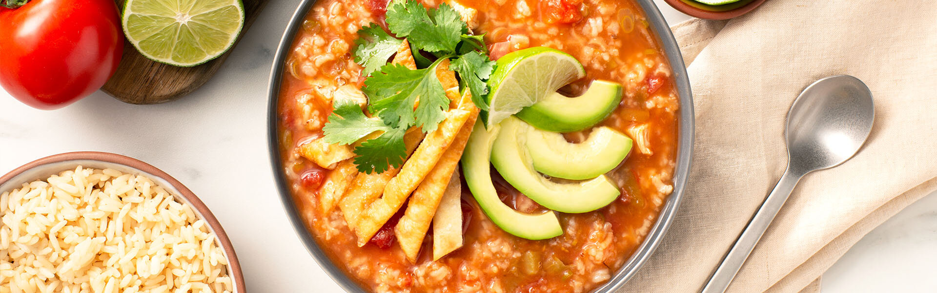 Chicken tortilla rice soup with avocado and lime