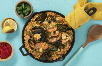 Traditional-Paella-Dish-with-Red-Bell-Peppers-Lime-Wedges-Chorizo-Shrimp-Mussels-and-Fresh-Parsley