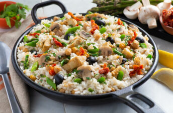 Skillet with vegetarian paella, black olives, mushrooms and