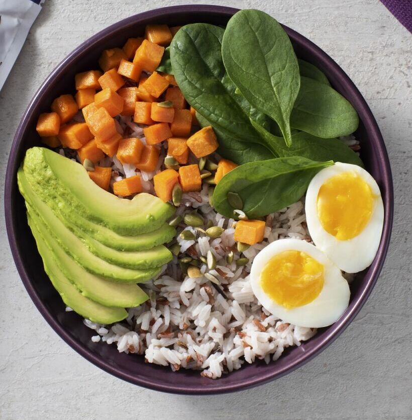 Breakfast rice bowl with turmeric rice, avocado and egg