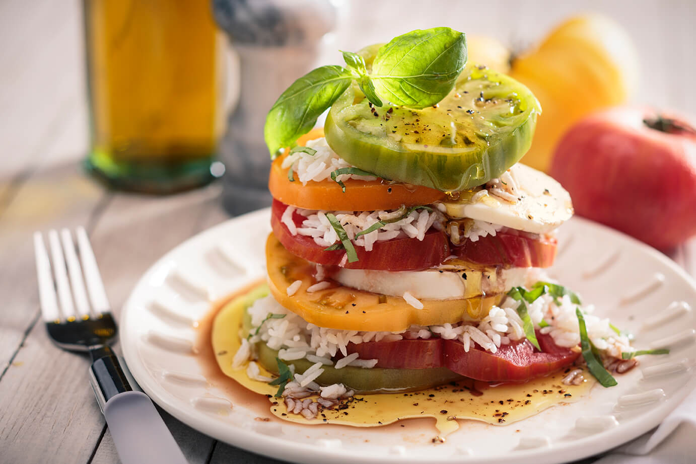 Layered caprese salad with white rice, basil and mozzarella